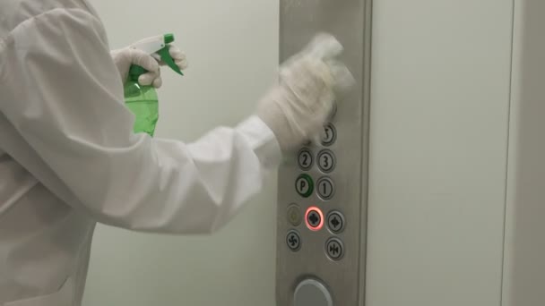 여자는 젖은 닦 개와 알코올 세척기 스프레이를 사용 해 엘리베이터 푸시 버튼 제어판을 닦는다. 감염, 청결 및 건강 관리, 안티 코로나 바이러스 COVID-19 — 비디오