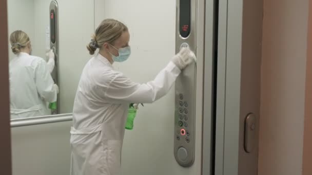 Wanita menggunakan pembersih basah dan pembersih alkohol semprot untuk membersihkan panel kontrol tombol lift. Disinfeksi, kebersihan dan perawatan kesehatan, Anti Coronavirus COVID-19 — Stok Video