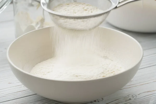 Tamisage de farine à travers un tamis pour une cuisson — Photo