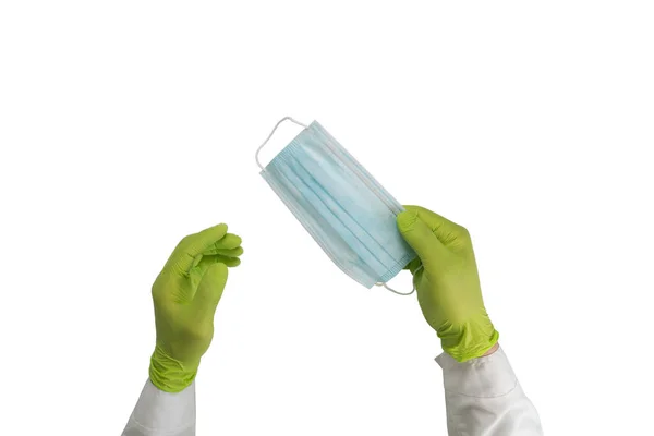 Hands in rubber gloves hold a protective medical mask. Surgical mask isolated on a white background. — Stock Photo, Image