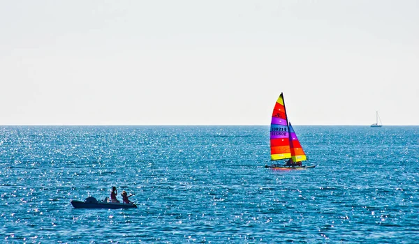 Summer beach with umbrellas and boat in the background — Stock Photo, Image