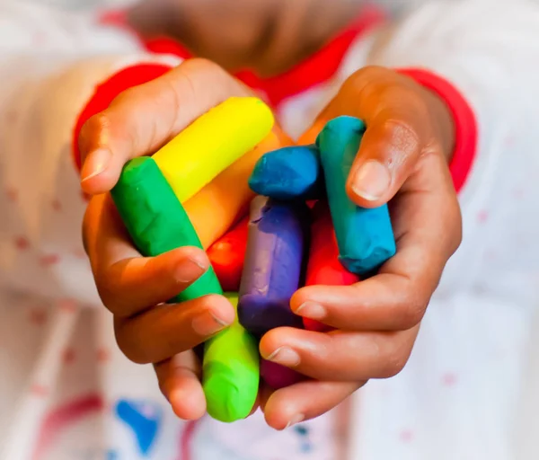 Petite fille joue avec l'argile de modélisation colorée — Photo