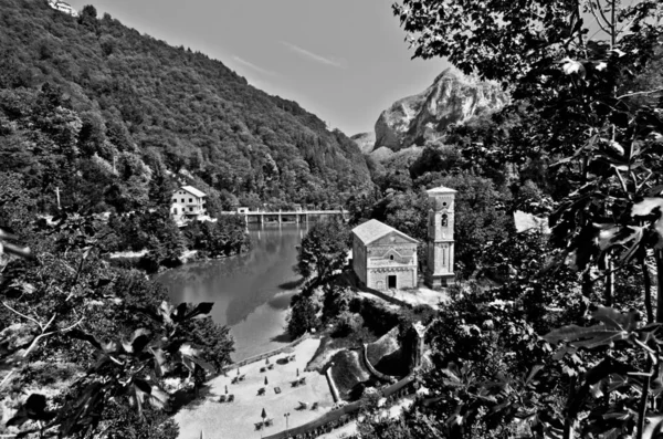 Lac de montagne avec petit hameau et église historique — Photo