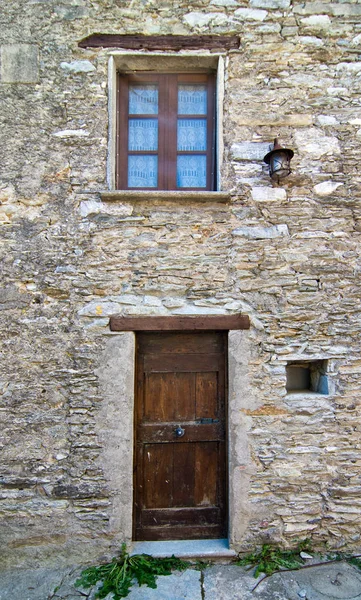 Dřevěné dveře s oknem ve staré kamenné budově — Stock fotografie