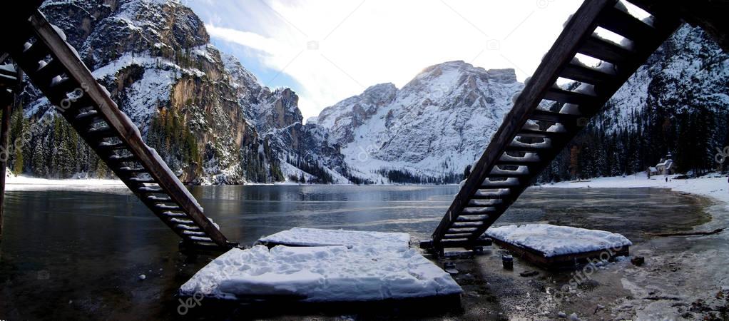 Braies lake framed by the stairs of the mountain lake boat shelt