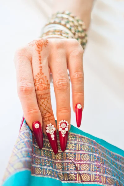 Uñas decoradas con brillantes y mano con tatuajes de henna — Foto de Stock