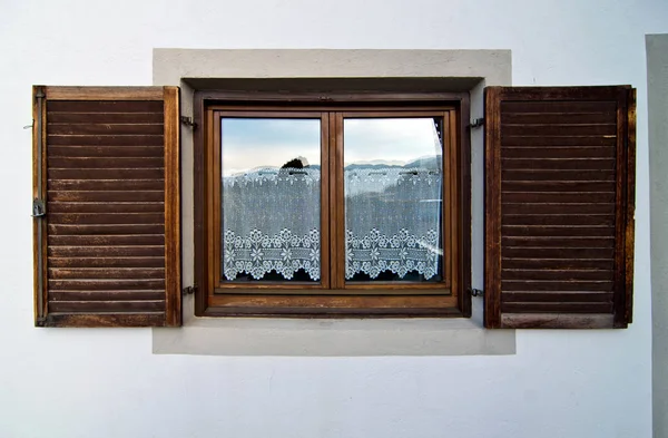 Fenêtre maison de montagne avec volets en bois et dentelle de verre — Photo