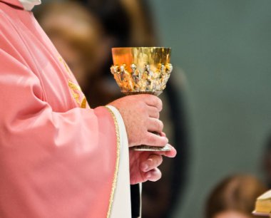 consecration of wine in the hands of the priest who addresses th clipart