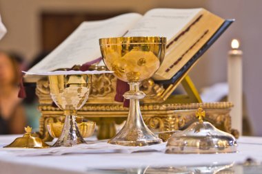 pisside and chalice contain wine and hosts on the altar of the m clipart