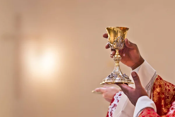 Mãos do sacerdote levantar o sangue de Cristo — Fotografia de Stock