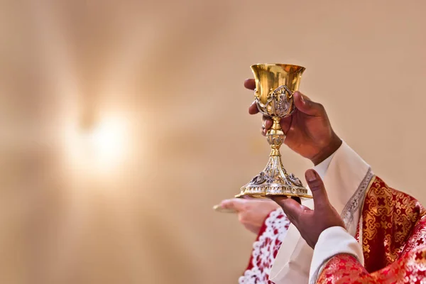 Mãos do sacerdote levantar o sangue de Cristo — Fotografia de Stock