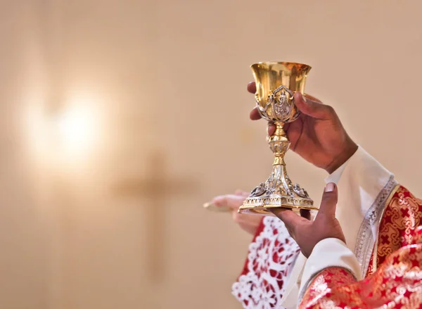 Mãos do sacerdote levantar o sangue de Cristo — Fotografia de Stock