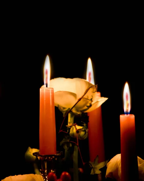 Κεριά που λάμπουν στο σκοτάδι και φωτίζουν τα τριαντάφυλλα που δίνεται από το — Φωτογραφία Αρχείου