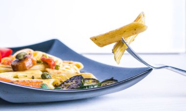 Besleyici ve sağlıklı makarna, renkli ve lezzetli sebzeli makarna ve kapari.