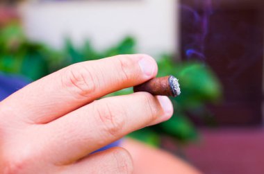 Mutlu yaşlı adam puroyu zevkle içiyor tatlı girdaplar ve duman bulutları arasında