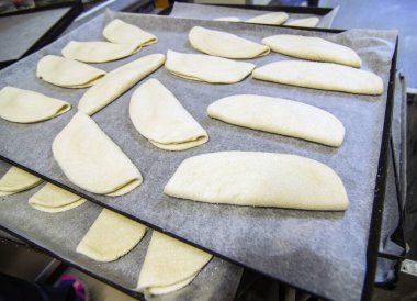 Esnaf laboratuarında hazırlanan gerçek hamur işleri, tatlılar, pastalar ve kekler, pişirilmeyi bekleyen ikramlar.