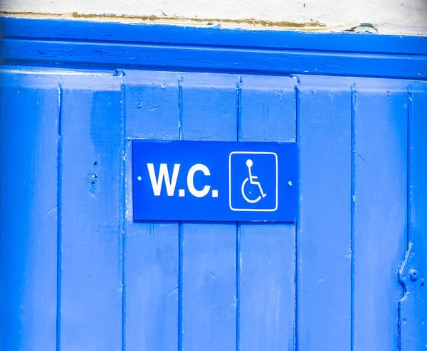 blue public bathroom door with sign for disabled people, right size for prams