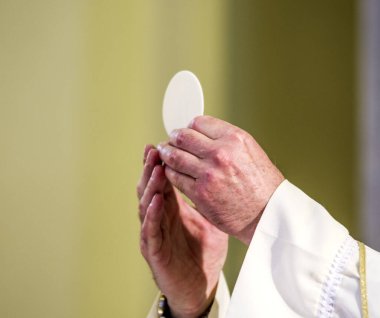 Ayin sırasında papazın elleri, Papa Francis 'in elleri gibi, İsa' nın bedenine dönüşen konukçuyu kutsa.