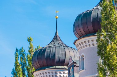 Dağlarda soğan çan kulesi olan kilise. Gotik tarzda. Mavi gökyüzünün altında güzel kokulu çiçekler.