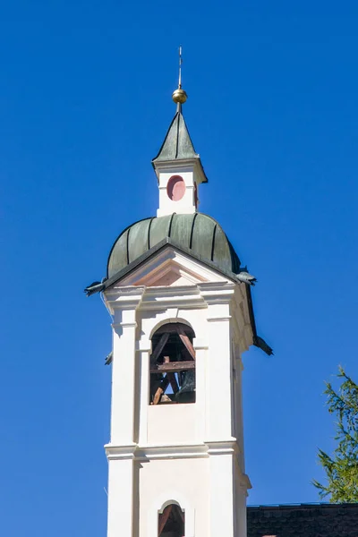 church with onion bell tower in the mountains in the Gothic style with fragrant flowers under the blue sky