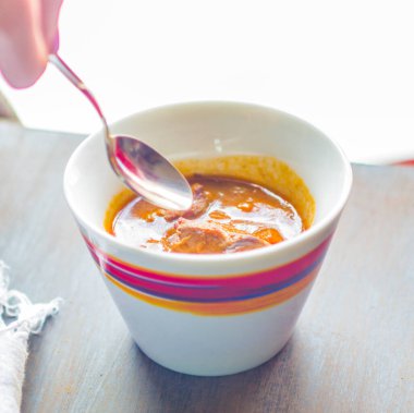 Lezzetli ve dumanı tüten sıcak bir çorba renkli süslemeler ve kaşık tutan bir kız.