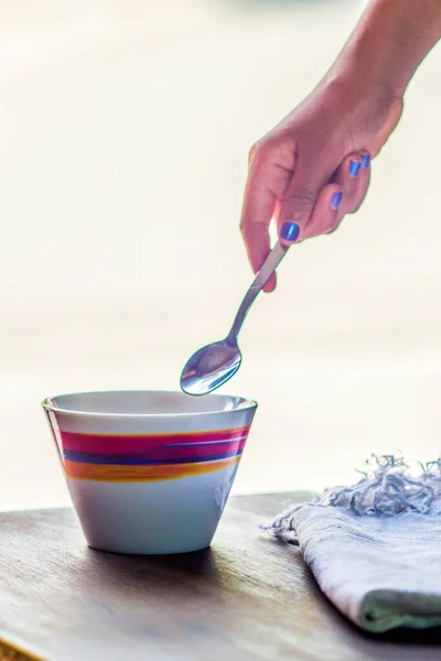 Menina Segura Uma Pequena Colher Sobre Uma Caneca Com Decorações — Fotografia de Stock