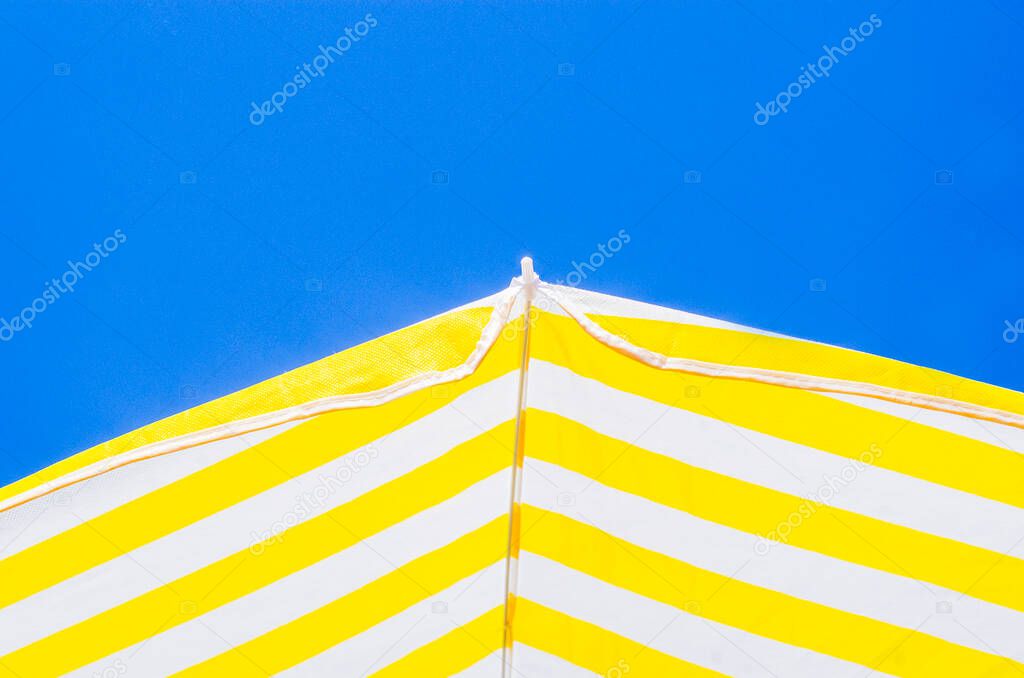yellow and white umbrellas with the blue sky in the background, three colors symbols of summer like paintings