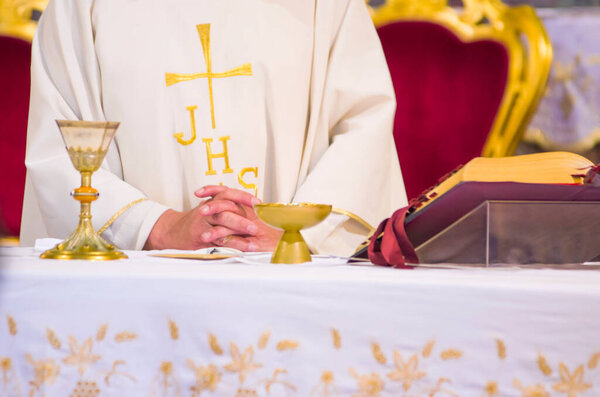 altar with host that becomes the body of jesus christ and chalice for wine, blood of christ, with the book for the mass of the faithful
