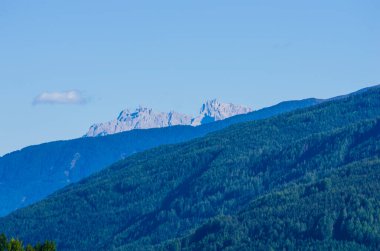 Dağlarda tatiller, dağlarda yaşamak, güzel güneş ışığına sahip yüksek dağlar, yeşil ormanlar ve keskin kayalıklı zirveler, açık gökyüzünün altında.