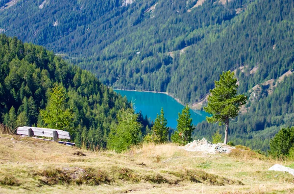 木制长椅 供徒步旅行者休息 欣赏高山上清澈的湖泊 绿茵的草地 茂密的森林和蓝天下锐利的岩石 — 图库照片