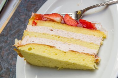 Sünger kek, çilek ve badem kreması reçelli çilek ve doğranmış badem garnitürle kaplı.