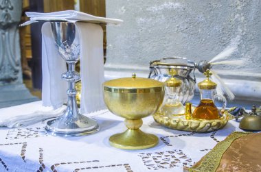 chalice for wine, blood of christ, and ciborium with host, body of christ, and ampoules with wine and water for the consecration on the others of the churches for pope francesco clipart