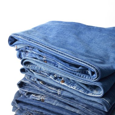 beyaz zemin üzerinde kot pantolon yığını