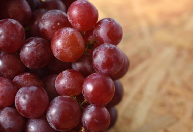 Ahşap masada bir demet kırmızı üzüm