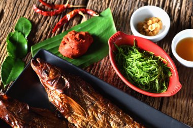 Kaliteli ahşap üzerinde balık soslu kızartma, mükemmel kızartma işlemi, kızartılması için levrek, sonra da balık sosu ile kaplanmış ve çerçevelenmiş olarak kızartmak için levreği getir..