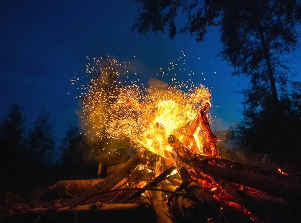 Feu lumineux lors d'une nuit sombre dans une clairière . — Photo