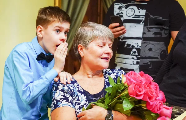 Το αγόρι ψιθυρίζει στο αυτί της γιαγιάς του και μοιράζεται τα νέα. . — Φωτογραφία Αρχείου