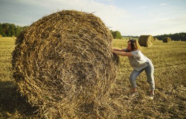 Çavdar tarlasında bir saman yığınının yanında duran genç bir kız