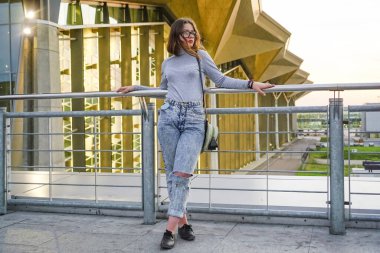 Havaalanı binasının arka planındaki genç kız. .