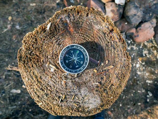 指南针安放在森林里的一个木制树桩上 向北方的箭 — 图库照片