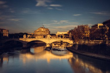 Fotoğraf Roma'da Tiber Nehri'nin ve köprü ile renkli bir gün batımında St Angelo's Castle