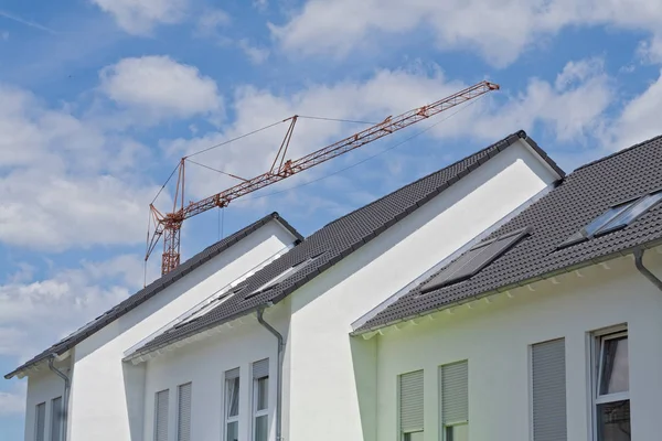 Dächer von drei neuen Reihenhäusern mit Baukran — Stockfoto