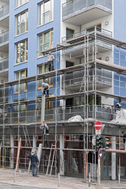 Mavi bir evin önünde bir iskele iskele inşaatçılar montajı
