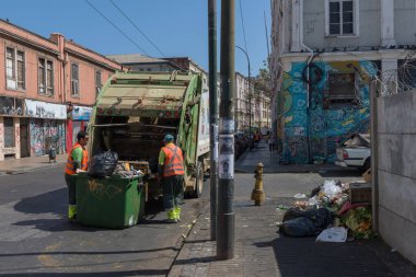 VALPARAISO, Şili - Şili 26 Şubat 2020: Çöp işçileri, Şili 'nin Valparaiso kentinin sokaklarında çöp konteynırları toplarken ev topluyorlar