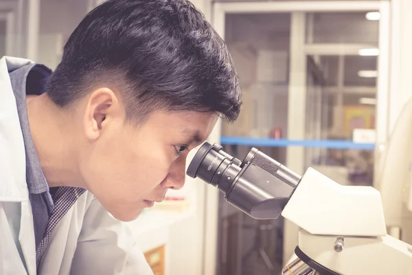 Asia científico trabajando en laboratorio biológico . — Foto de Stock