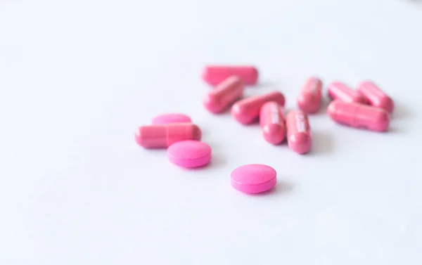Růžové tabletky na bílém pozadí — Stock fotografie