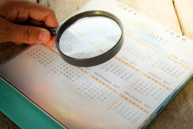 Bir büyüteç kullanarak işadamı çalışma raporu. takvim yılında.