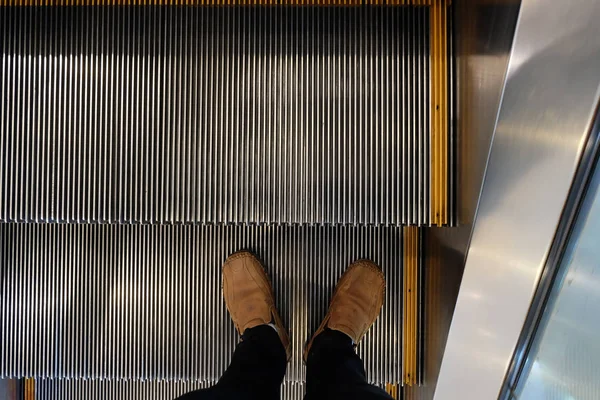 The close up shot of human walking on the escalator processing