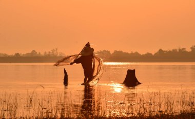 RI siluet üzerinde bir balıkçı teknesi nehirde balık tutma erkekler güneş
