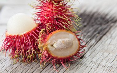 Ahşap doku arka plan üzerinde taze rambutan.